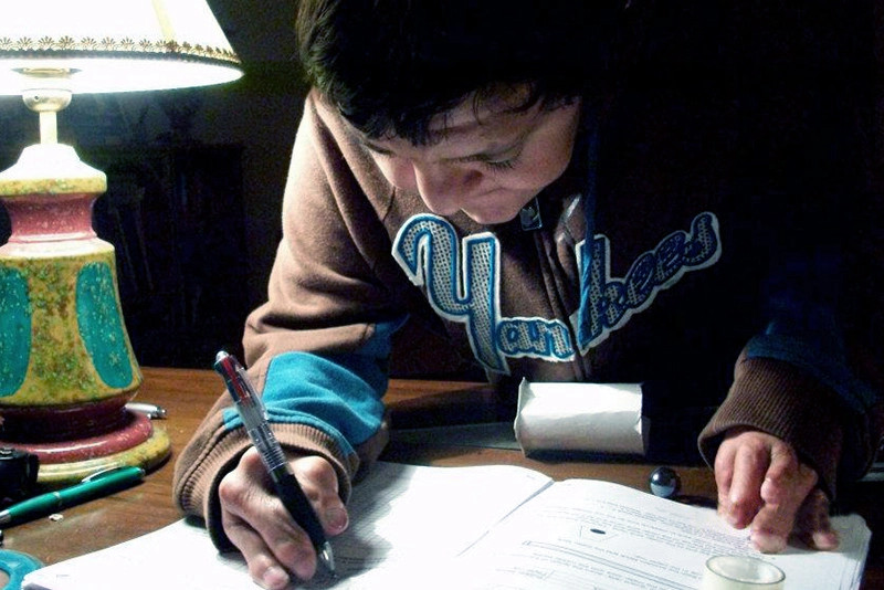a child with apert syndrome writing with a pen